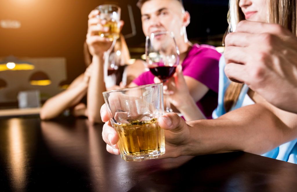 Friends drinking beer and wine in a pub.