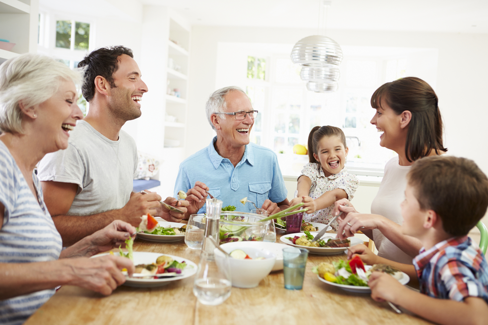 Multi Generation Family Eating Meal Around Kitchen Table. Family holiday dinner was fantastic, now it's time to know how to get back on track after all the holiday food.