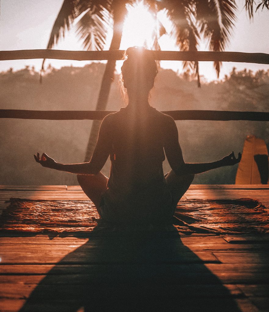 Woman meditating in the sunrise.