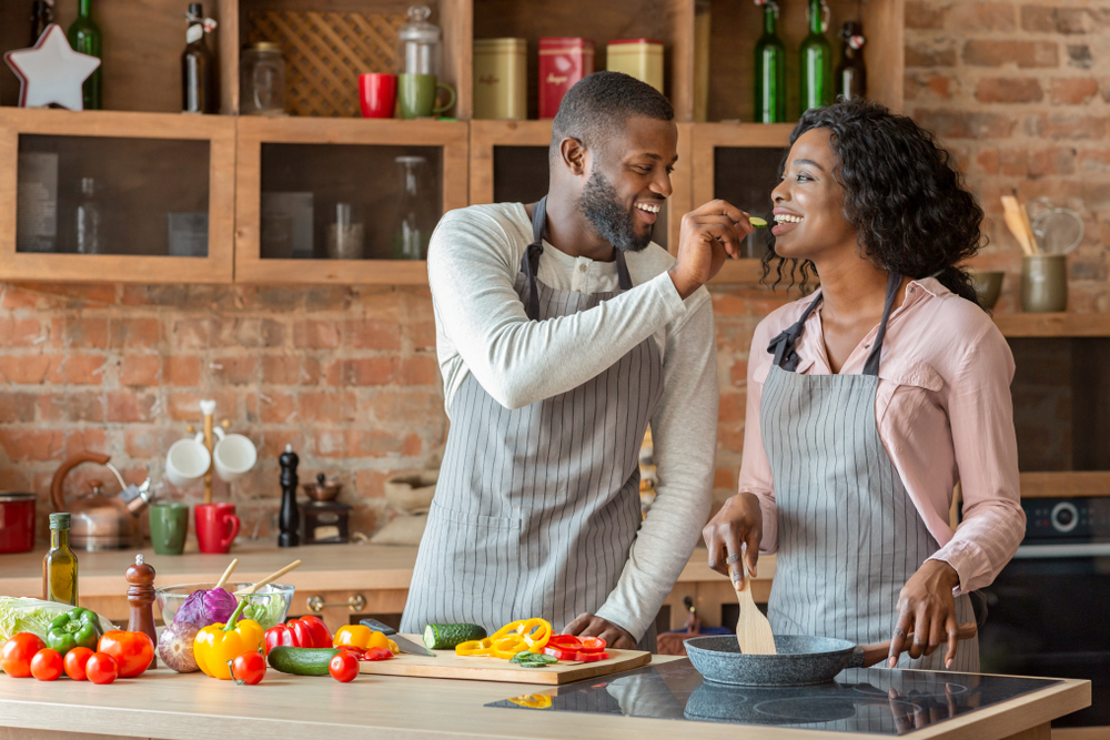 Couple preparing vegetables in kitchen.