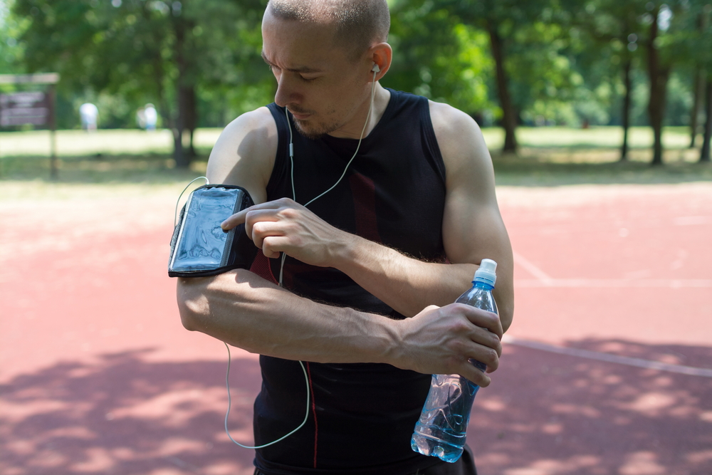 Man touching phone on arm sleeve.