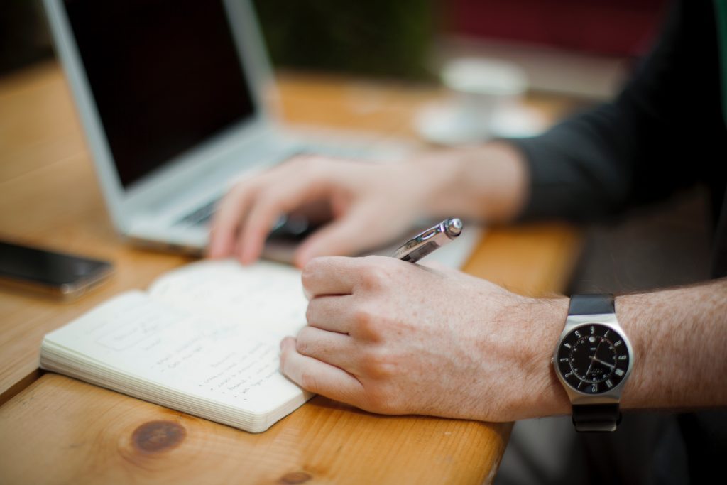 Man writing on his diary. Journaling for mental health improvement is a proven practice.