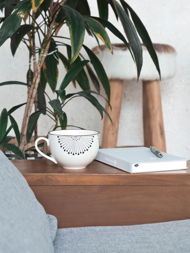 A journal placed on table next to a coffee mug.