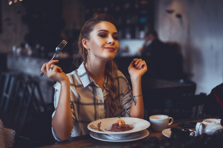 Woman enjoying her dinner in a restaurant.