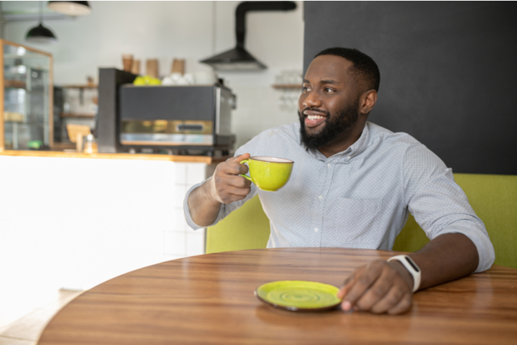 Guy is sitting in the cozy cafe and enjoys laird superfood matcha instafuel.