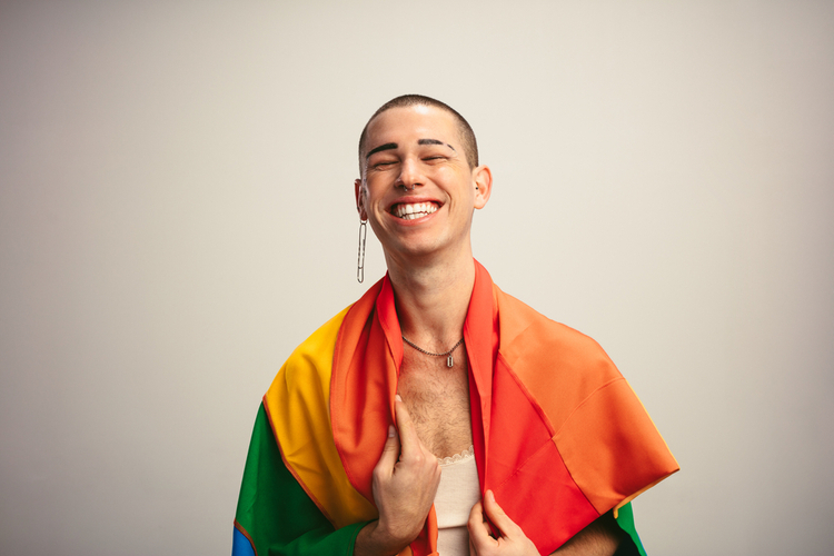 Gender fluid male with lgbt flag against white background.