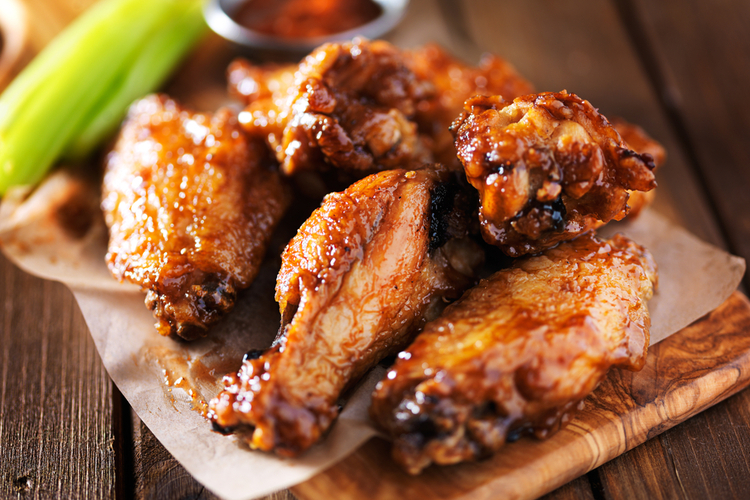 Ninja foodi Air Fryer chicken wings close up on wooden tray shot.