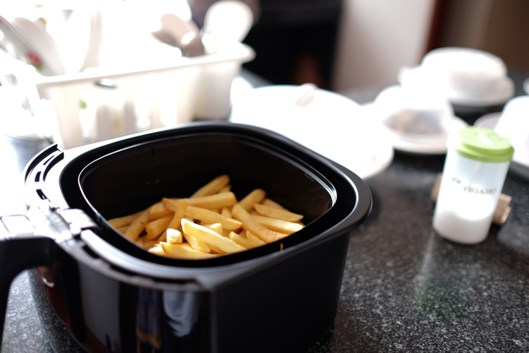 Home-made french fries in modern air fryer.