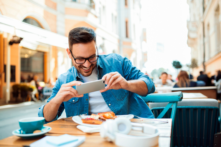 Smiling modern young man taking picture of his meal.