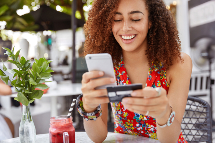 A woman happily using her mobile banking app.