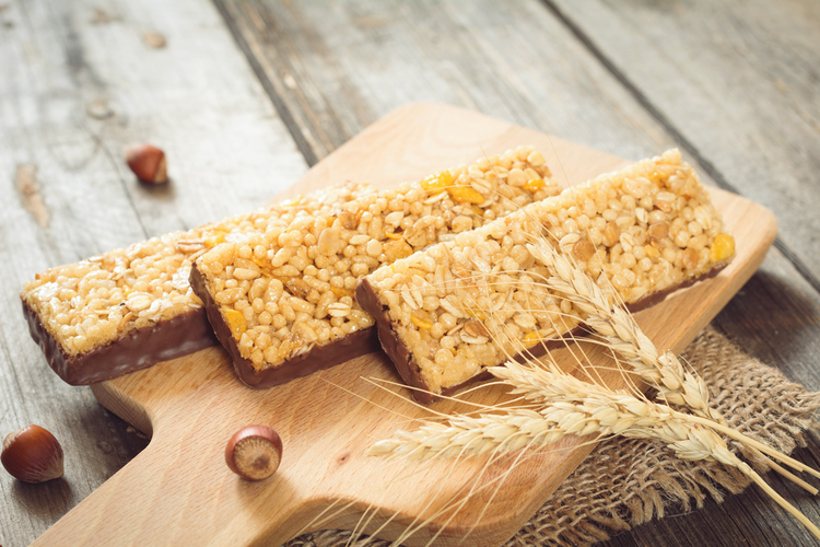 Energy bars, Granola Bars, Muesli Bars And Wheat Cereals on Wooden Cutting Board