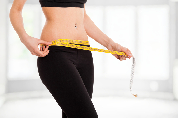 Woman controlling her measures using a tape burning fat fast.