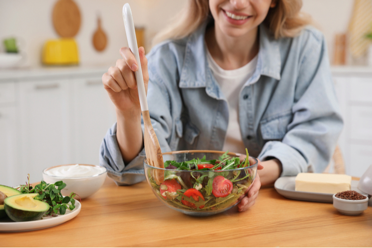 Woman with keto diet at wooden table in kitchen
