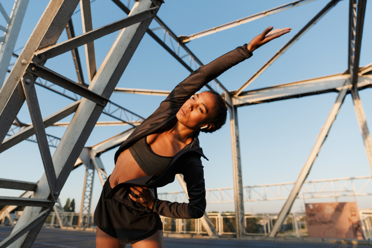 stretching her body while working out on old bridge