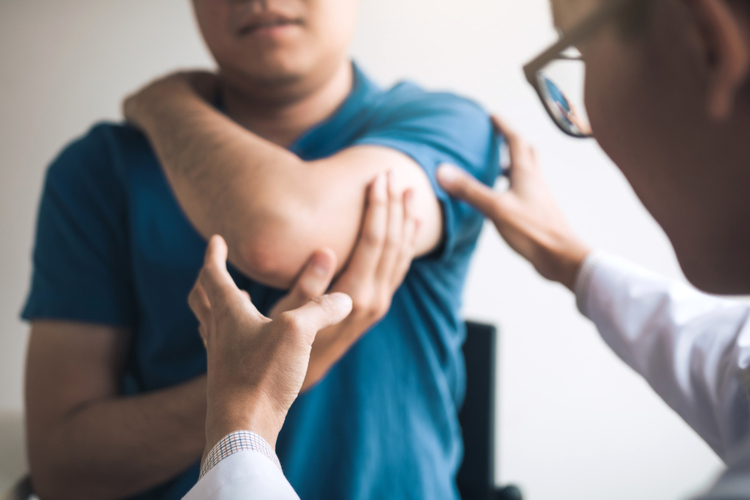 Physical therapists are checking patients elbows at the clinic office room.