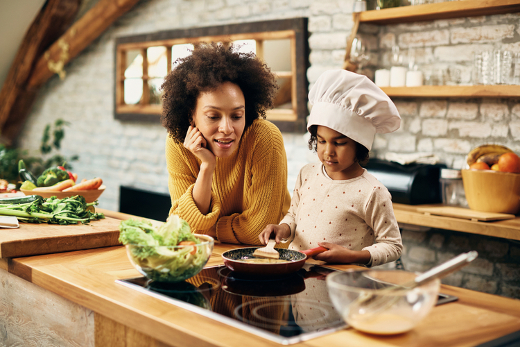 Little girl and her mom making chickpea fritters without an air fryer style.