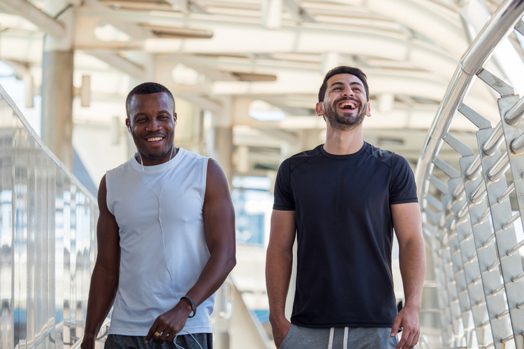 Two lgbtq athletes male laughing while walking