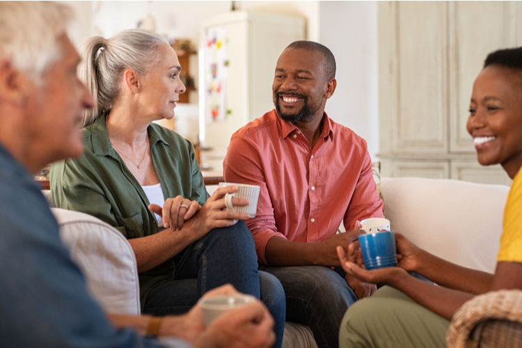 Senior and mature couples in conversation at home.