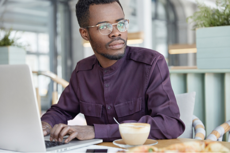 Serious thoughtful dark skinned businessman focused on work issues