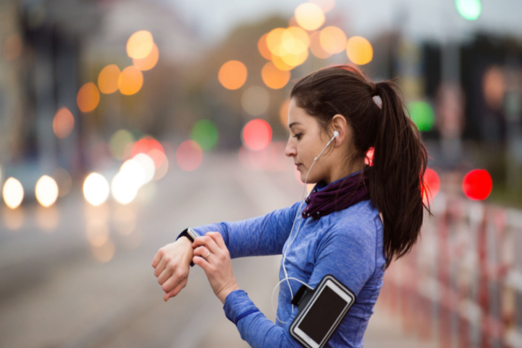 Young woman in blue sweatshirt running in the city
