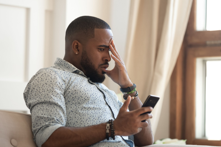 Male sit on couch feel frustrated by unexpected bad news