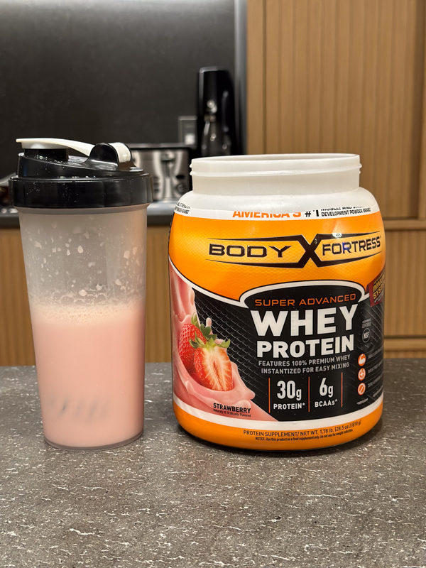 Body Fortress Whey Protein strawberry taste test next to mixer bottle